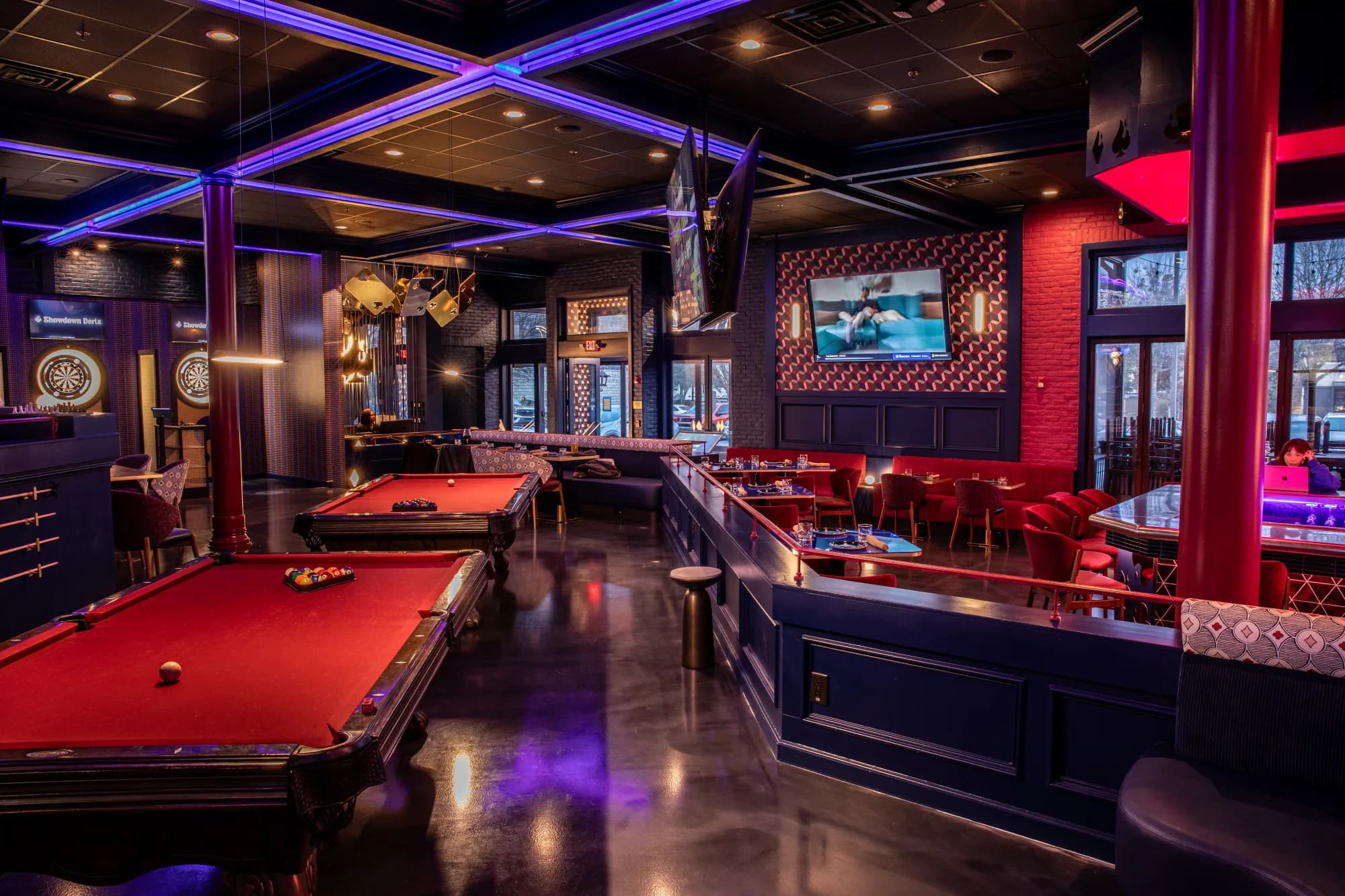Pool tables lit under the neon at Showdown Social