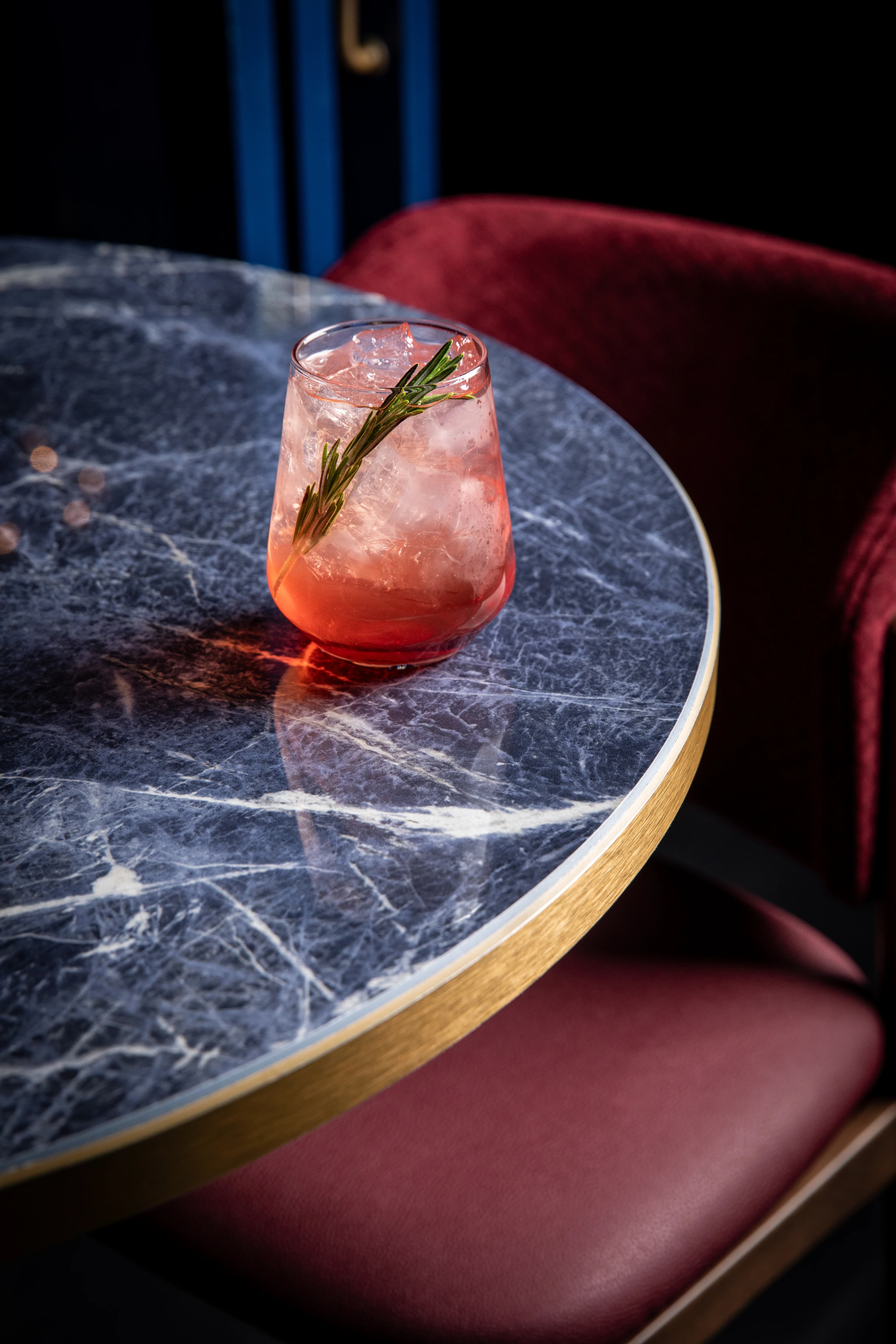 A rosemary cocktail on a high-top table at Showdown Social