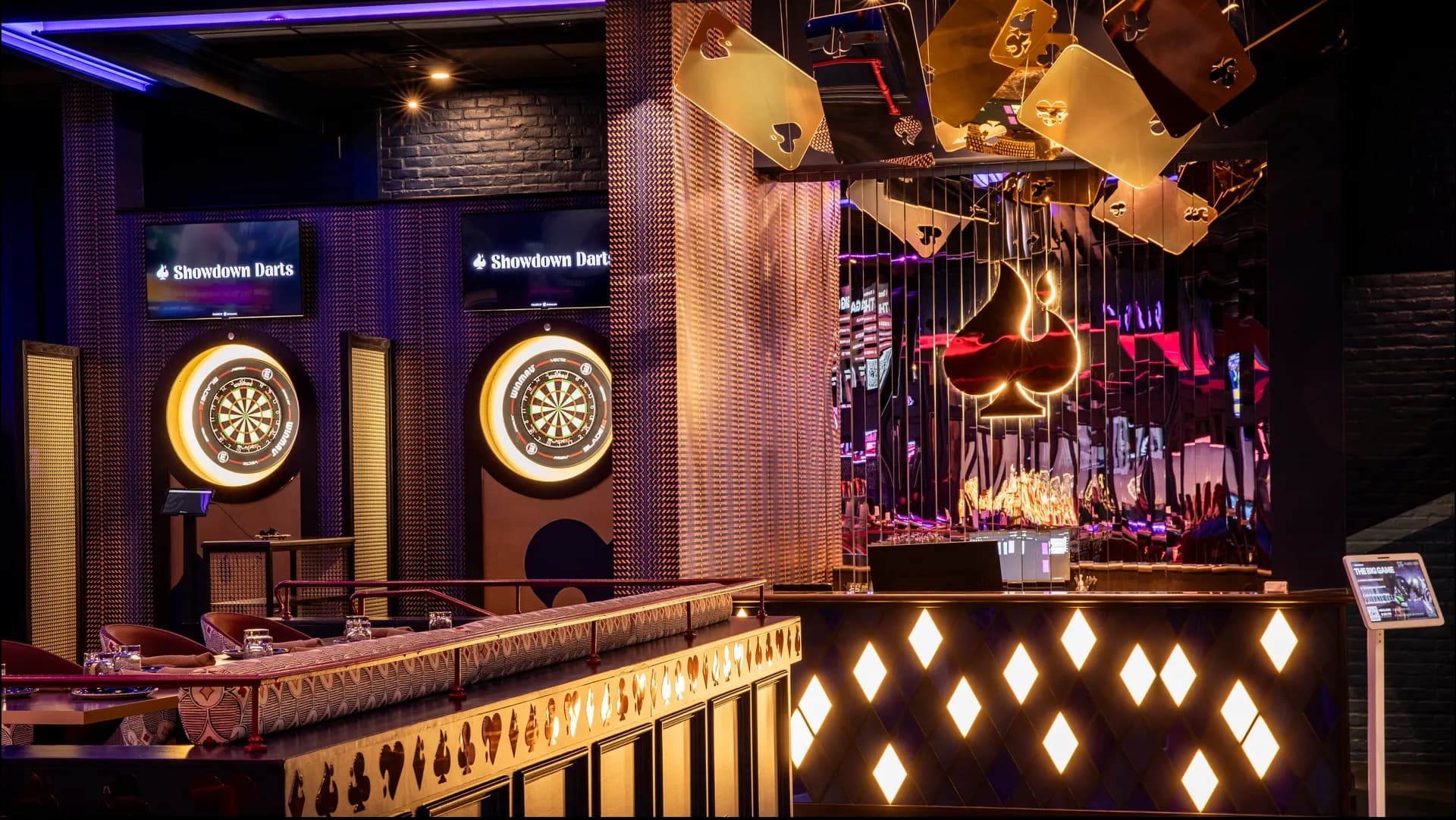 The dart wall and bar lit up on a Monday night at Showdown Social